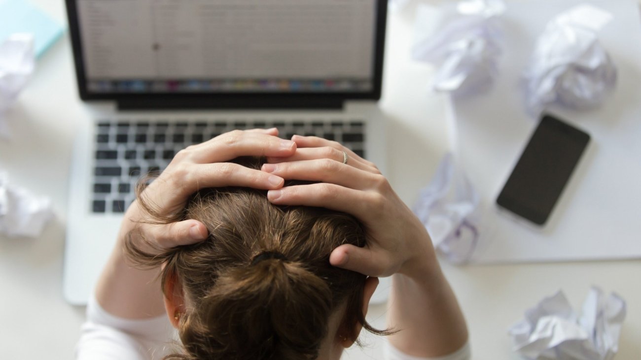 portrait-woman-grabbing-head-desk-near-laptop-Aq2qLjJ1Wgijeqry